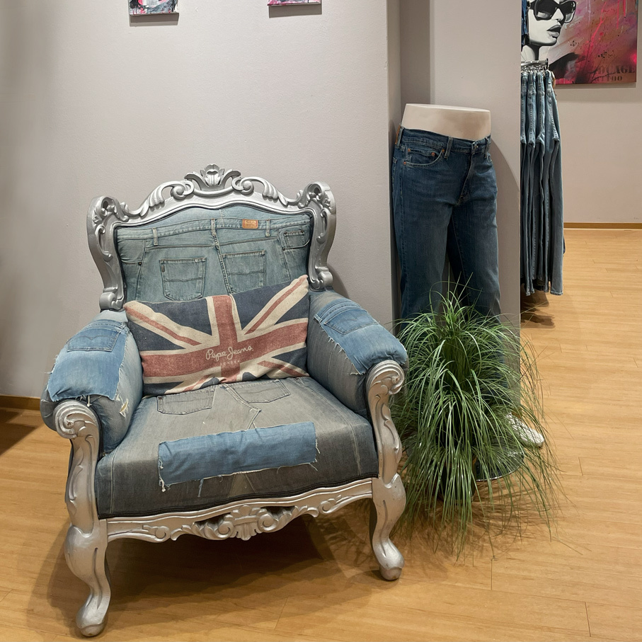 Mit Denim bezogener Sessel im Verkaufsraum des Original Jeans Store